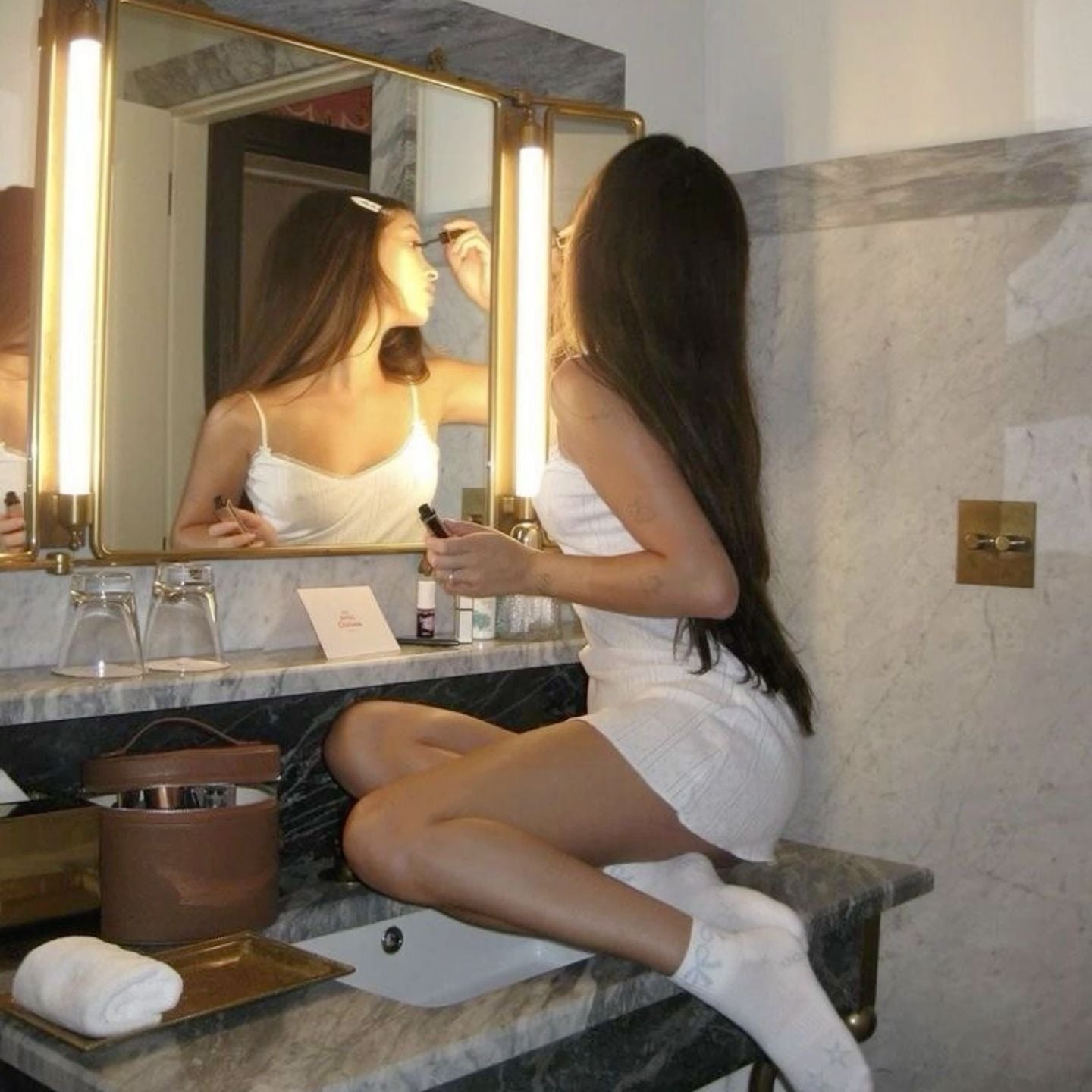 Two women doing their makeup in a hotel mirror