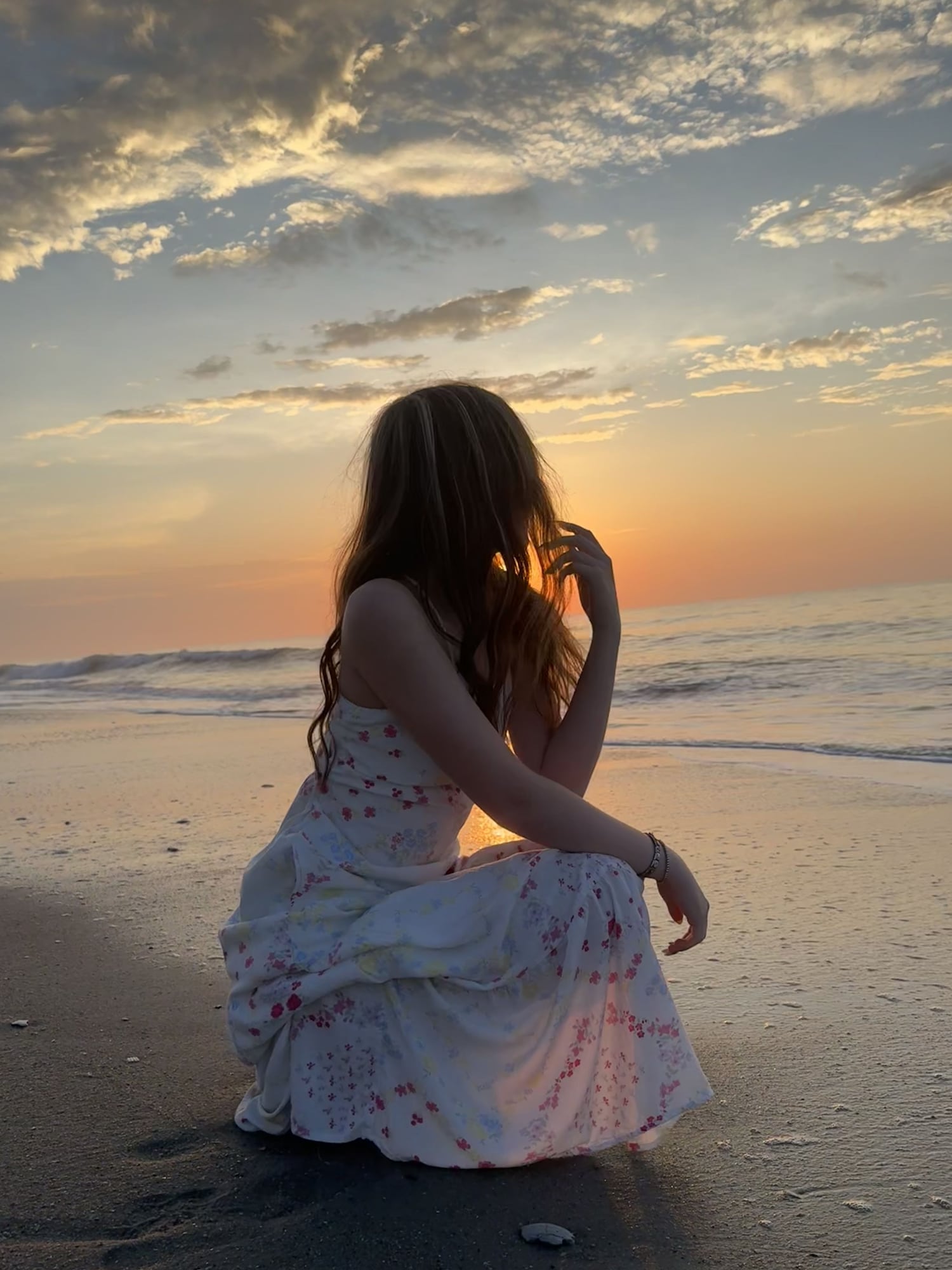 Woman watching the sunset on an empty beach