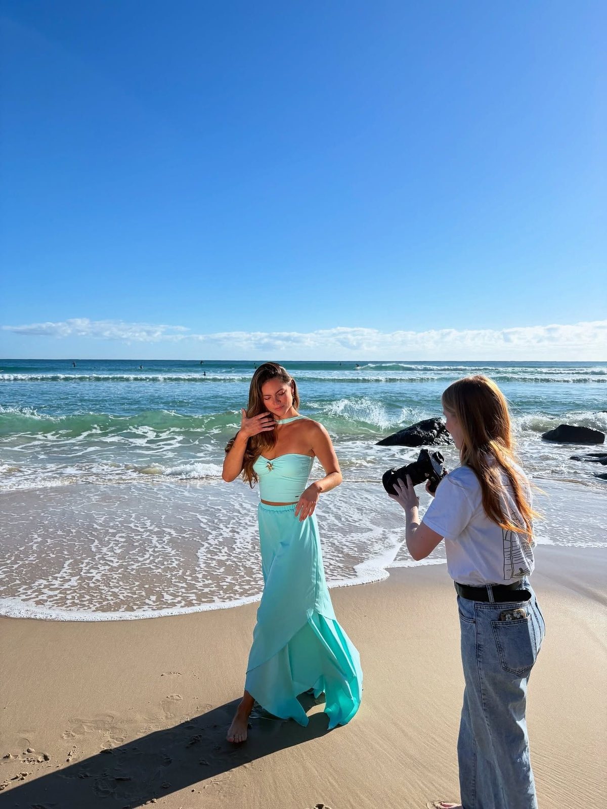 Photographer filming a woman on the beach